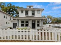 Charming two-story home featuring a white picket fence, gray accents, and a welcoming front porch at 5501 N 15Th St, Tampa, FL 33610