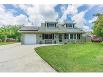 Charming single-story home with well-manicured lawn, brick exterior, solar panels, and a long driveway at 9201 86Th Ave, Seminole, FL 33777