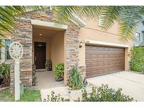 Inviting front entrance with stone accents, a dark wood door, and well-maintained landscaping for a welcoming feel at 11818 Valhalla Woods Dr, Riverview, FL 33579