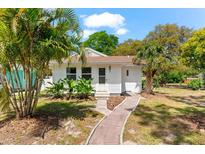 Charming single story home featuring mature landscaping and a welcoming front entrance at 1232 Sedeeva S Cir, Clearwater, FL 33755