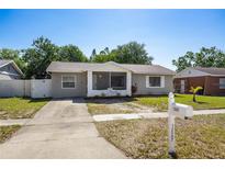 Charming single-story home with a well-maintained lawn and a welcoming screened entryway at 12597 Cumberland Dr, Largo, FL 33773