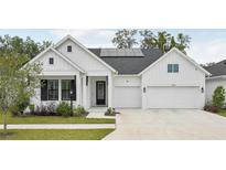 Modern farmhouse with white siding, black shutters, two car garage and solar panels on the roof at 13460 Bergamont Cir, Tampa, FL 33618