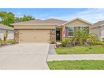 Charming single-story home featuring a two-car garage, beautiful landscaping, and a welcoming front entrance at 13675 Paddington Way, Spring Hill, FL 34609