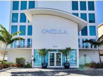 Striking building entrance featuring modern architecture, clear glass doors, and palm tree accents at 19816 Gulf Blvd # 602, Indian Shores, FL 33785