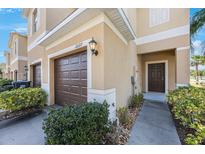 Exterior view of a well-maintained two-story townhome with a garage and landscaped front entrance at 2227 Golden Falcon Dr, Ruskin, FL 33570