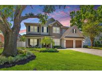 Charming two-story home featuring a well-manicured lawn, mature trees, and a two-car garage at 4010 W Leona St, Tampa, FL 33629