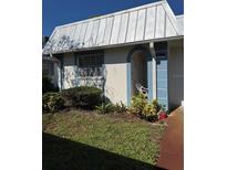 Charming home exterior with a metal roof, blue trim and an open, arched porch entrance at 4217 Tamargo Dr # A, New Port Richey, FL 34652