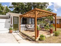 Inviting patio with pergola, stylish seating, and lush potted plants create a cozy outdoor space at 4527 24Th S Ave, St Petersburg, FL 33711