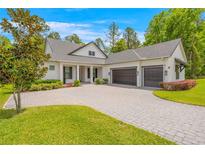 Beautiful two-story home featuring a three car garage, manicured landscaping, and a light colored driveway at 4581 Majestic Hills Loop, Brooksville, FL 34601