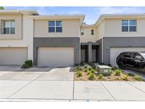 Two-story townhome featuring a one-car garage and neutral-toned siding with gray accents at 6406 Sanctuary Creek Ln, Tampa, FL 33625