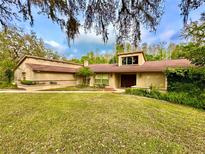 Charming single-story home with a well-maintained lawn, mature trees, and inviting landscaping at 10206 Lakeview Dr, New Port Richey, FL 34654