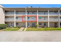 Exterior view of a three-story condo building with white railings and well-maintained landscaping at 10215 Regal Dr # 21, Largo, FL 33774
