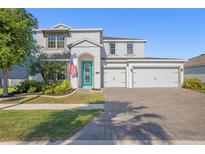 Charming two-story home with a three-car garage, manicured lawn and a brick paved drive at 11854 Lake Lucaya Dr, Riverview, FL 33579