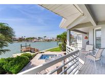 Relaxing back porch overlooking waterfront featuring a spa and an attractive view of the canal at 17382 Kennedy Dr, North Redington Beach, FL 33708