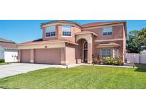 Charming two-story home with landscaped yard, a three-car garage, and a well-maintained lawn at 1751 Split Fork Dr, Oldsmar, FL 34677