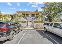 A bright two-story condo featuring a red tile roof, landscaped grounds, and convenient parking at 1800 Mariner Dr # 2, Tarpon Springs, FL 34689