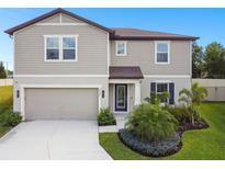 Charming two-story home with a well-manicured lawn, attached garage, and lovely landscaping at 6700 Devlin Ln, Wesley Chapel, FL 33545