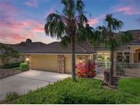 Charming single-story home featuring lush landscaping, a three-car garage, and a tiled roof at 13143 Palmilla Cir, Dade City, FL 33525