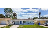 Charming single-story home with a well-maintained lawn and a lovely blue front door at 1734 Shore Acres Ne Blvd, St Petersburg, FL 33703