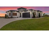 Contemporary home featuring a lush lawn, a driveway, and a stylish two-car garage at 3610 Gulf City Rd, Ruskin, FL 33570