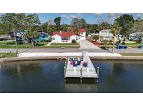 Beautiful waterfront home with private dock, featuring colorful chairs for relaxing and enjoying the water views at 4151 Sunrise S Dr, St Petersburg, FL 33705