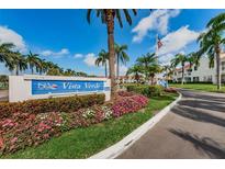 Welcoming community entrance sign with lush landscaping and palm trees under a bright blue sky at 6077 Bahia Del Mar Blvd # 123, St Petersburg, FL 33715