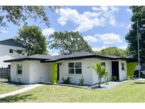 Charming single-story home with a manicured lawn and crisp white exterior paint at 7101 N 9Th St, Tampa, FL 33604