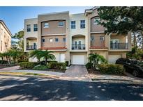 Townhouse exterior boasts a Mediterranean style, private balconies, attached garage, and vibrant landscaping at 805 100Th N Ave, St Petersburg, FL 33702