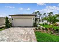 Charming single-Gathering home with a two-car garage and a beautifully paved driveway and walkway, and manicured lawn at 9535 Coastline Way, Parrish, FL 34219