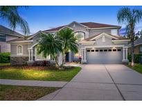 Two-story home featuring well-maintained landscaping and a spacious three car driveway and tropical trees at 10130 Deercliff Dr, Tampa, FL 33647