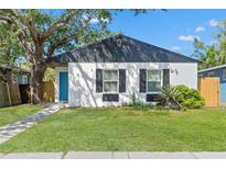 Charming home with a well-manicured lawn, black shutters, and a welcoming blue front door at 1843 38Th S St, St Petersburg, FL 33711