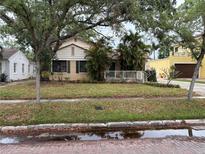 Charming bungalow with tropical landscaping, brick street, and a cozy front porch with white railing at 2923 W Coachman Ave, Tampa, FL 33611