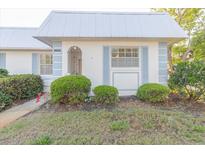 Inviting home with a metal roof, blue trim, and well-maintained landscaping at 4235 Tamargo Dr # 4235, New Port Richey, FL 34652