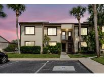 Inviting two-story condo with lush landscaping and palm trees, set against a colorful twilight sky at 428 Moorings Cove Dr # 7F, Tarpon Springs, FL 34689