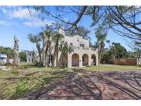 Stately home featuring arched porch, palm trees, and classic architectural detailing on a sunny day at 636 Sunset S Dr, St Petersburg, FL 33707