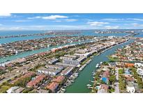 Stunning aerial view of a waterfront community with canals, boats, and city skyline in the background at 903 Pinellas Bayway S # 308, Tierra Verde, FL 33715