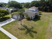 Well-maintained single Gathering home with lush green lawn and palm tree in a serene neighborhood at 9304 Nile Dr, New Port Richey, FL 34655