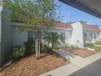 Charming single-story home featuring a red roof, well-maintained lawn, and inviting walkway leading to the entrance at 13813 Mission Oaks Blvd, Seminole, FL 33776