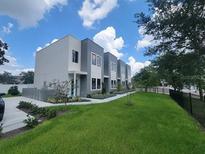 Modern townhouse with a well-maintained lawn and sleek architectural design in a desirable neighborhood at 2108 E 22Nd Ave # 1, Tampa, FL 33605