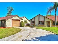 Inviting home featuring a well-manicured lawn, a spacious driveway, and an attached two-car garage at 2459 Bay Berry Dr, Clearwater, FL 33763