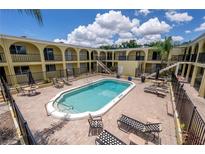 Well-maintained community pool area with lounge chairs and lush landscaping, perfect for relaxation at 3206 W Azeele St # 218, Tampa, FL 33609