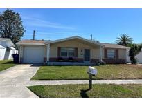 Charming single-story home featuring an attached garage and well-maintained front yard at 3330 Monticello St, Holiday, FL 34690