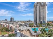 Stunning aerial shot of a condo community with a pool and manicured grounds, all set against a cityscape backdrop at 449 S 12Th St # 504, Tampa, FL 33602