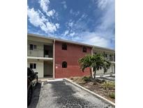 Building exterior showing brick facade, balconies, and landscaping with a small palm tree at 4550 Overlook Ne Dr # 156, St Petersburg, FL 33703