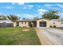 Charming single-story home with a well-maintained lawn, stone garden, and inviting screened-in garage at 8141 82Nd Ave, Seminole, FL 33777
