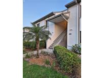 Condo exterior featuring well-maintained landscaping and a staircase leading to upper-level units at 281 Cypress Ln, Oldsmar, FL 34677