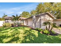 Charming single-story home featuring a well-manicured lawn and inviting landscaped front yard at 2988 Sugar Bear Trl, Palm Harbor, FL 34684
