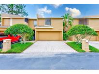 Inviting townhome with a two-car garage, manicured landscaping, and paver driveway at 4212 Mill Valley Ct, Tampa, FL 33618