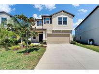 Beautiful two-story home with a well-manicured lawn and a two-car garage on a sunny day at 4513 Eternal Prince Dr, Sun City Center, FL 33573