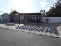 Charming home featuring a covered patio with chairs and an extended brick paved driveway, offering curb appeal and outdoor living at 8822 Rocky Creek Dr, Tampa, FL 33615